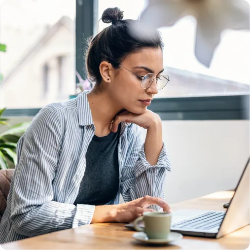 A developer working at a laptop in a bright cafe